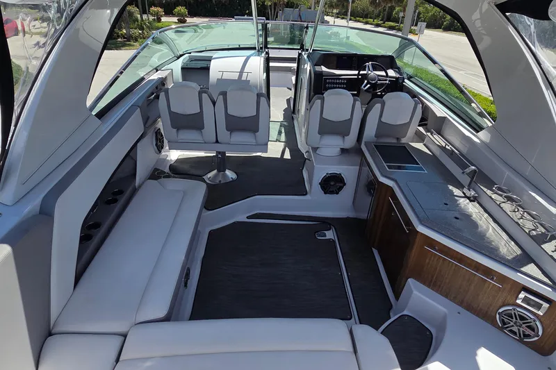 Slide: The Image of 2019 Four Winns H350 OB boat interior with seating, helm, and kitchenette. - 33