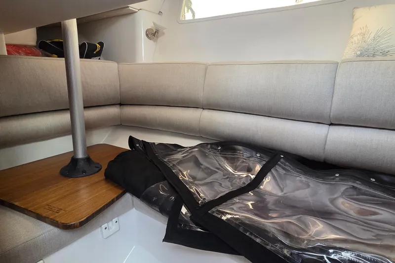 Slide: The Image of Interior of 2019 Four Winns H350 OB boat with cushioned seating and wooden table. - 41