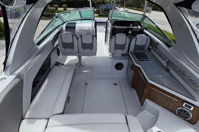Slide: The Image of 2019 Four Winns H350 OB boat interior with seating, helm, and kitchenette. - 6