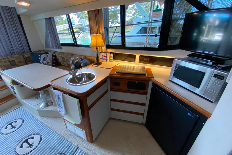 Slide: The Image of Interior of 1991 Carver 28 Command Bridge with kitchenette and dining area. - 11