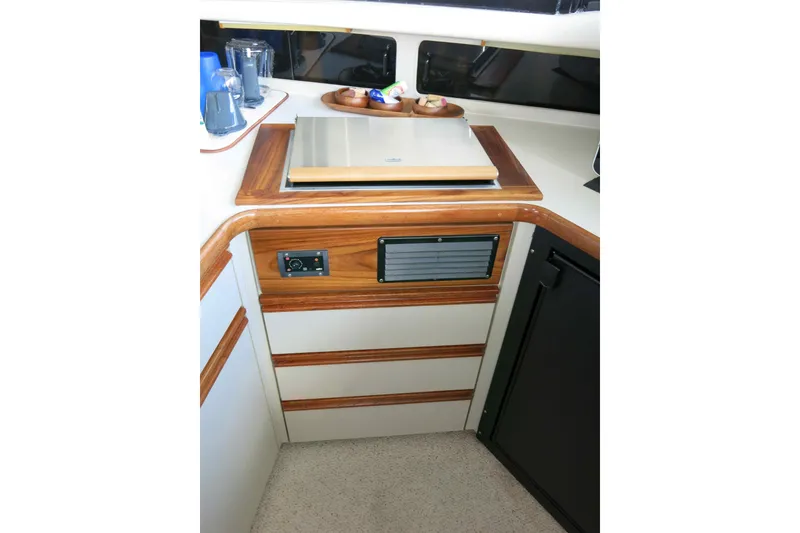 Slide: The Image of 1991 Carver 28 Command Bridge kitchen area with stove and storage cabinets. - 13