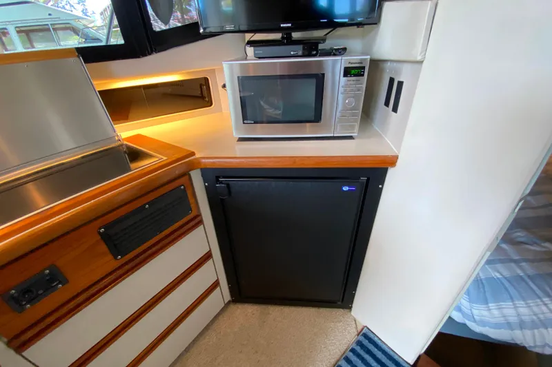 Slide: The Image of Interior of 1991 Carver 28 Command Bridge with microwave and mini fridge. - 15
