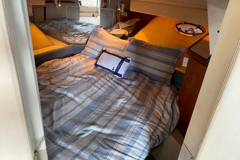 Slide: The Image of Cozy cabin interior of 1991 Carver 28 Command Bridge with striped bedding. - 18