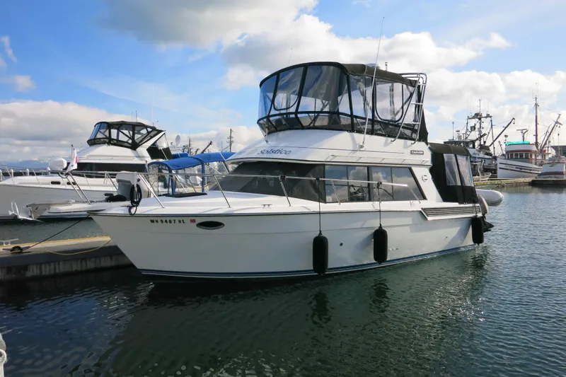 Slide: The Image of 1991 Carver 28 Command Bridge yacht docked in a marina under a blue sky. - 2