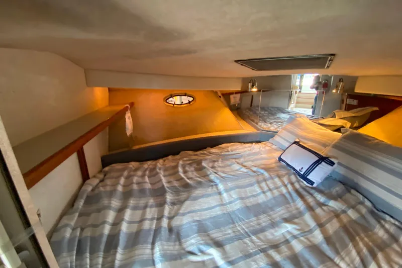 Slide: The Image of Cozy cabin interior of 1991 Carver 28 Command Bridge with striped bedding and nautical decor. - 20
