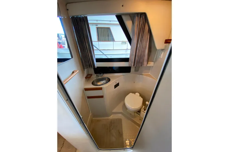 Slide: The Image of Bathroom interior of 1991 Carver 28 Command Bridge yacht, featuring sink and toilet. - 21
