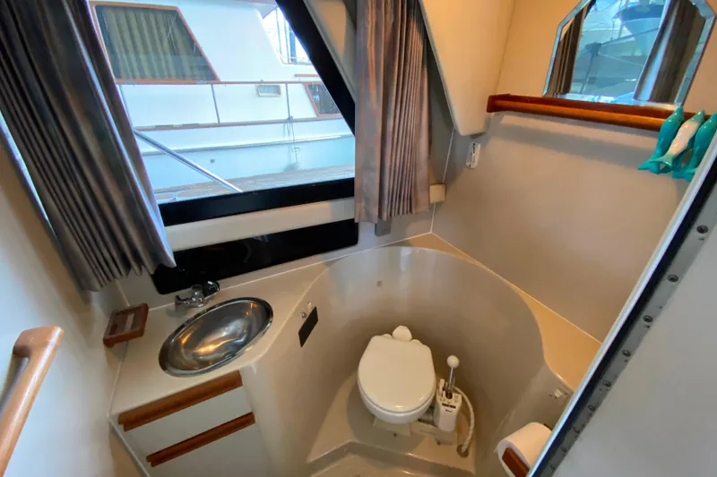 Slide: The Image of Bathroom interior of 1991 Carver 28 Command Bridge yacht, featuring sink and toilet. - 22