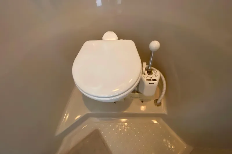 Slide: The Image of 1991 Carver 28 Command Bridge marine toilet with manual flush lever. - 25