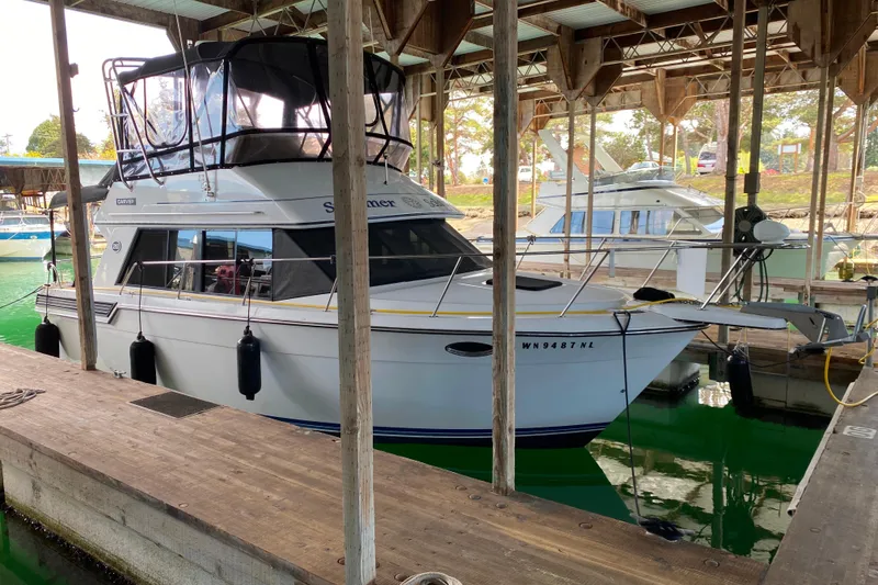 Slide: The Image of 1991 Carver 28 Command Bridge docked in a covered marina. - 3