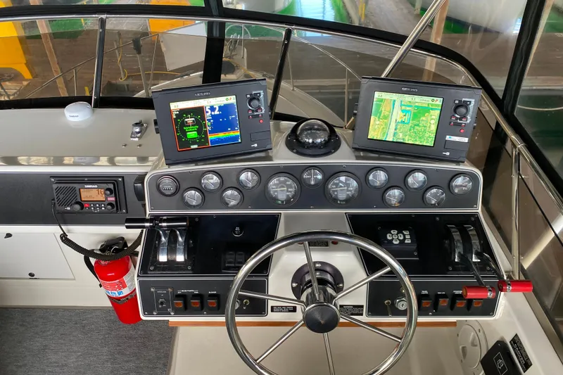 Slide: The Image of 1991 Carver 28 Command Bridge helm with navigation screens and controls. - 39