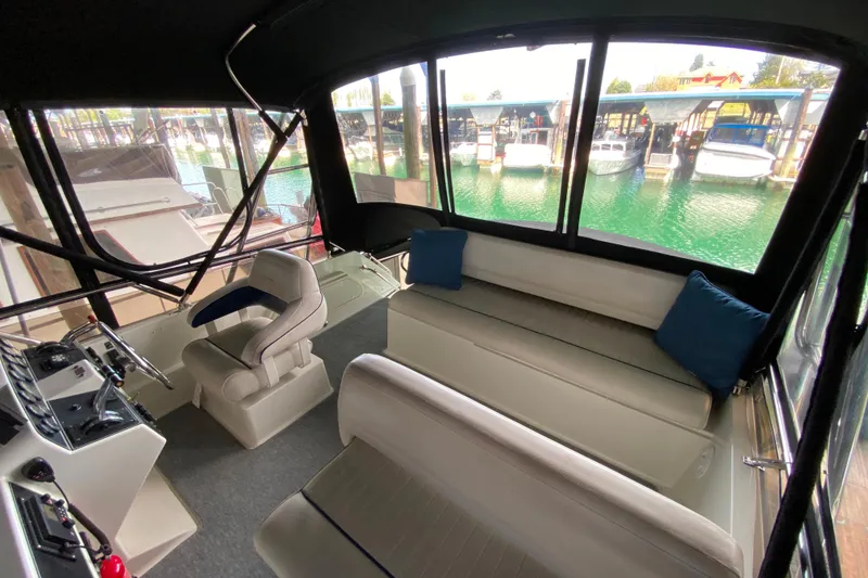 Slide: The Image of Interior of a 1991 Carver 28 Command Bridge with seating and helm, overlooking marina. - 41