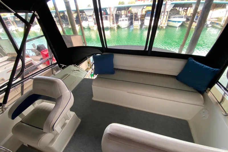 Slide: The Image of Interior of 1991 Carver 28 Command Bridge with seating and marina view. - 42