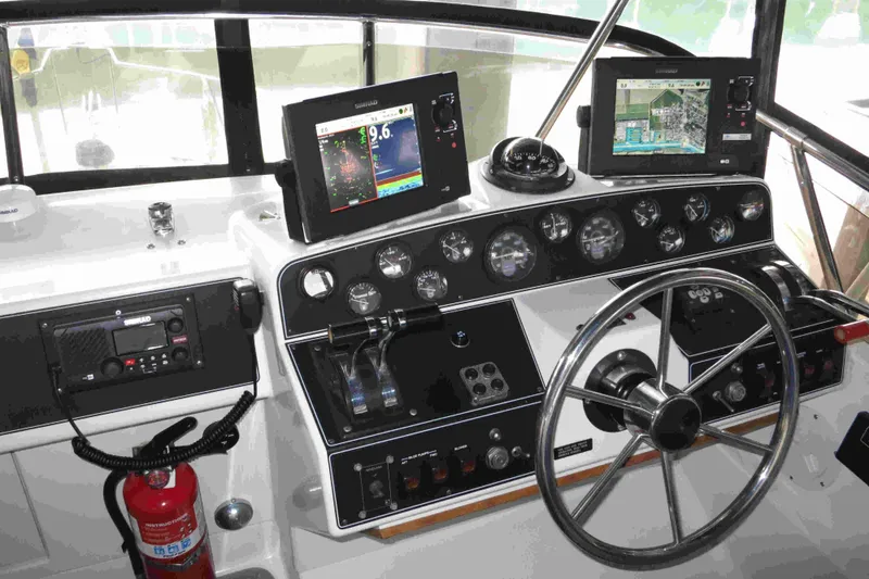 Slide: The Image of 1991 Carver 28 Command Bridge helm with navigation screens and steering wheel. - 46