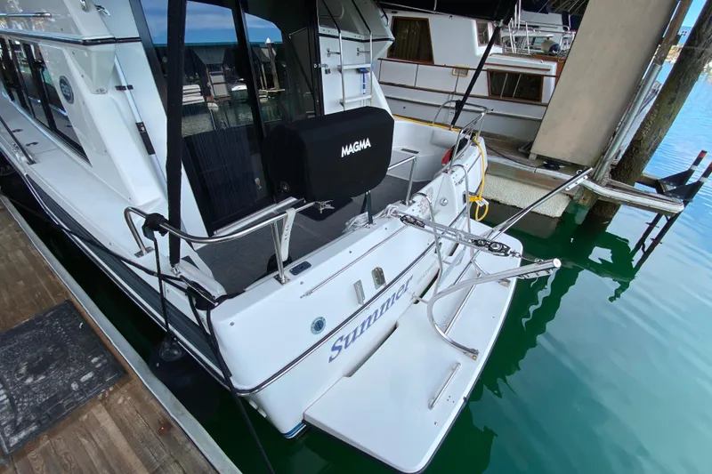 Slide: The Image of 1991 Carver 28 Command Bridge docked, featuring a spacious rear deck and sleek design. - 59
