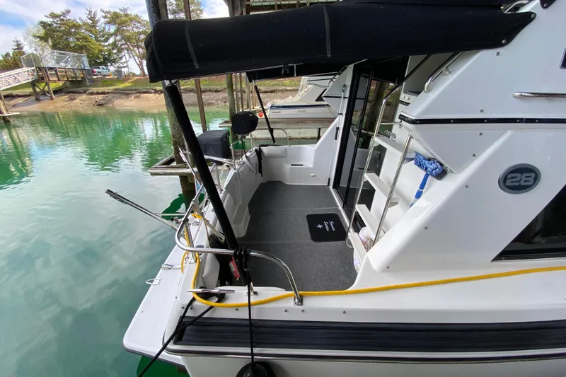 Slide: The Image of 1991 Carver 28 Command Bridge docked, featuring spacious deck and sleek design. - 65