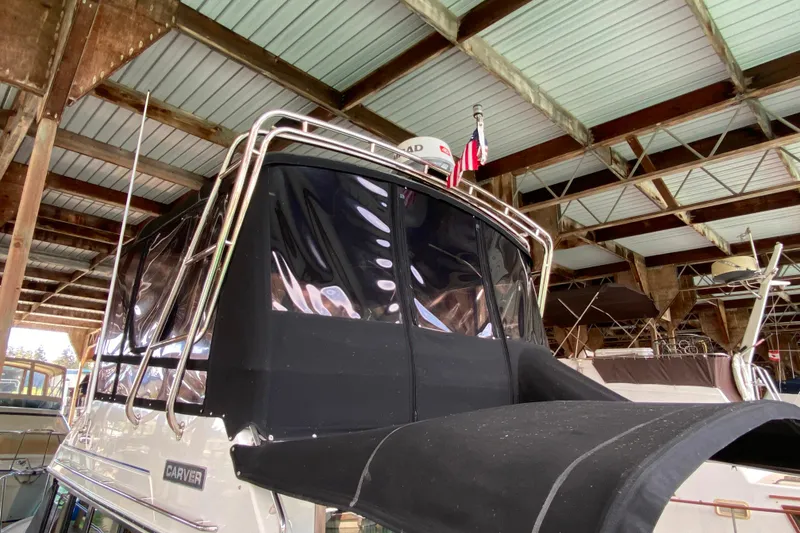 Slide: The Image of 1991 Carver 28 Command Bridge yacht under covered dock, featuring black canvas enclosure. - 69