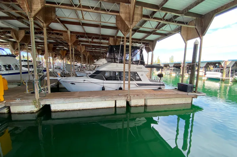 Slide: The Image of 1991 Carver 28 Command Bridge docked in a covered marina. - 73