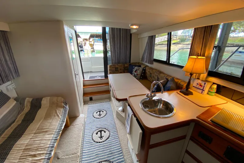 Slide: The Image of Interior of a 1991 Carver 28 Command Bridge with cozy seating and kitchenette. - 9