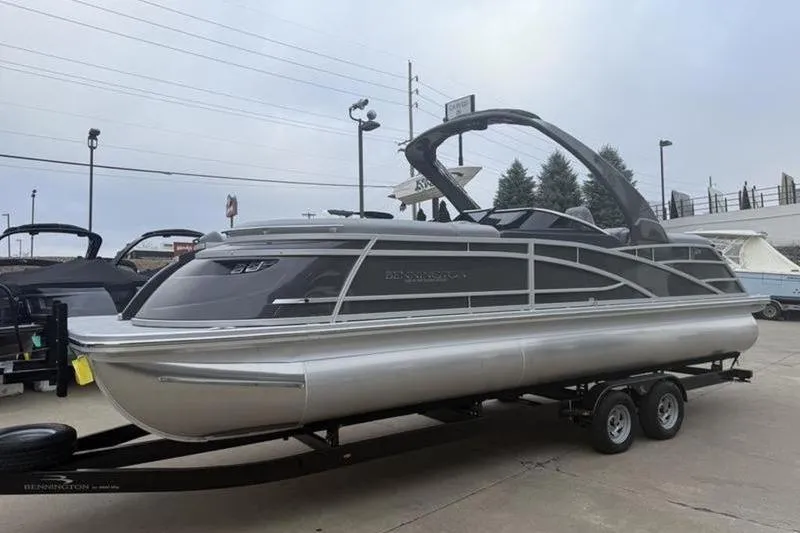 The Image of 2026 Bennington 25 QFBWA pontoon boat on trailer, displayed outdoors. - 1
