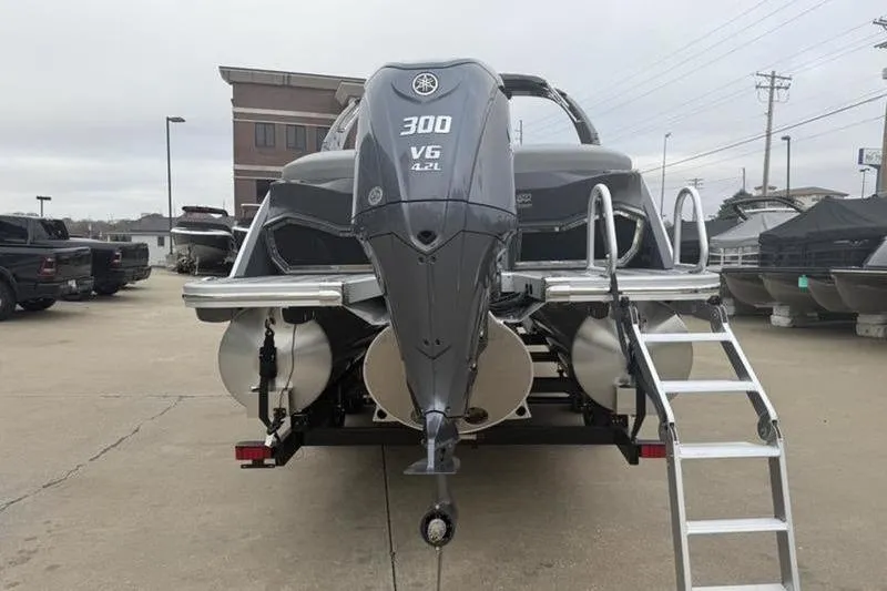 Slide: The Image of 2026 Bennington 25 QFBWA boat with Yamaha 300 V6 engine, rear view in a marina. - 6