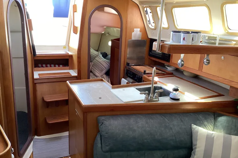 Slide: The Image of Interior of a 1999 Hunter 340 sailboat featuring a cozy kitchen and seating area. - 12