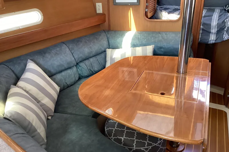 Slide: The Image of Cozy interior of 1999 Hunter 340 sailboat with wooden table and cushioned seating. - 13