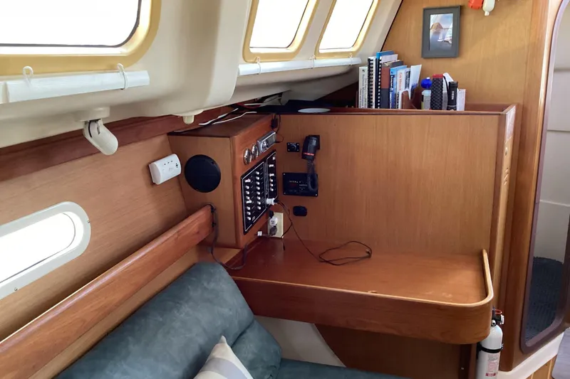 Slide: The Image of Interior of a 1999 Hunter 340 sailboat with navigation station and bookshelves. - 14