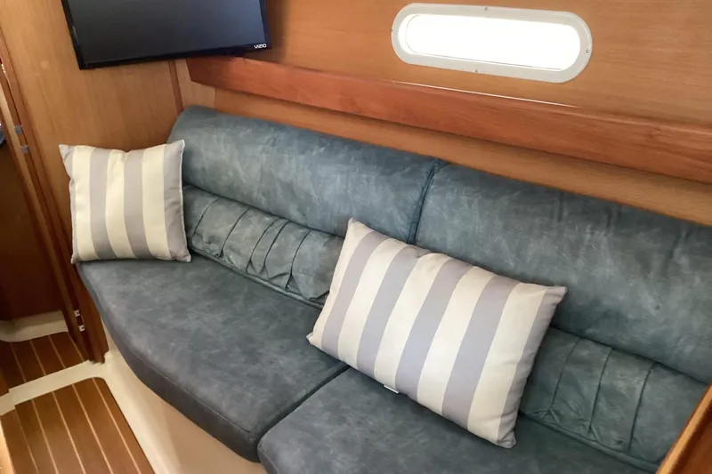 Slide: The Image of Interior of a 1999 Hunter 340 sailboat with blue sofa and striped pillows. - 15