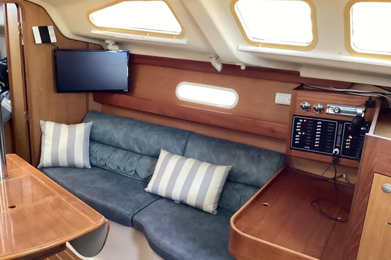 Slide: The Image of Interior of 1999 Hunter 340 sailboat with cozy seating and control panel. - 16
