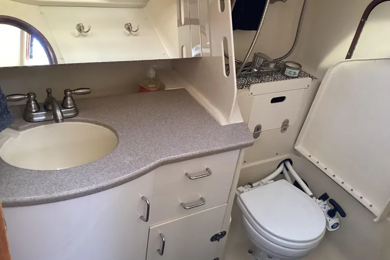 Slide: The Image of Compact bathroom in a 1999 Hunter 340 sailboat with sink, mirror, and marine toilet. - 19
