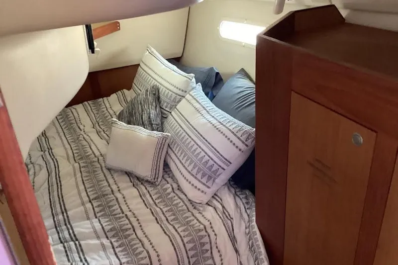 Slide: The Image of Cozy cabin interior of 1999 Hunter 340 sailboat with patterned bedding and wooden cabinetry. - 23