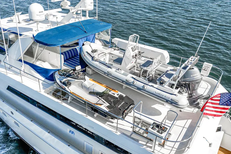 Slide: The Image of 1995 Nordlund Cockpit Motor Yacht with tender and jet ski on deck, American flag visible. - 10