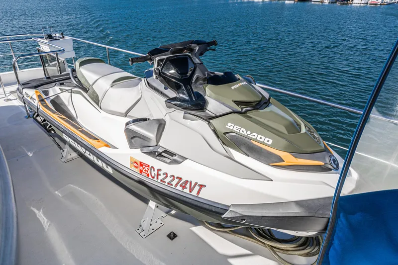 Slide: The Image of Jet ski on 1995 Nordlund Cockpit Motor Yacht deck, overlooking blue water. - 12