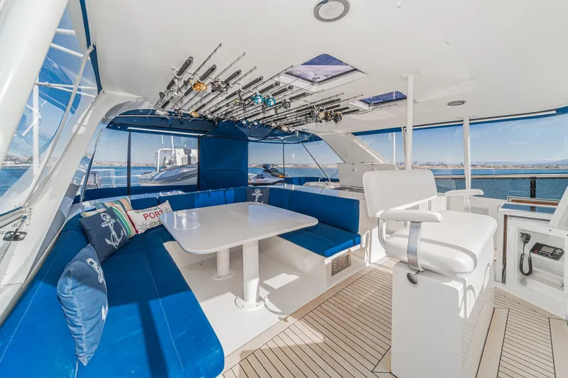 Slide: The Image of 1995 Nordlund Cockpit Motor Yacht interior with blue seating, fishing rods, and ocean view. - 21