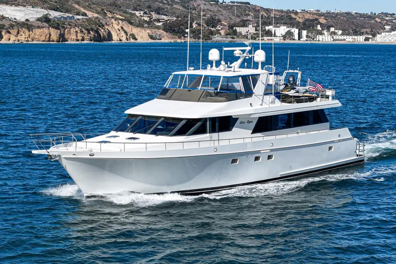 Slide: The Image of 1995 Nordlund Cockpit Motor Yacht cruising on blue water near rocky coastline. - 4