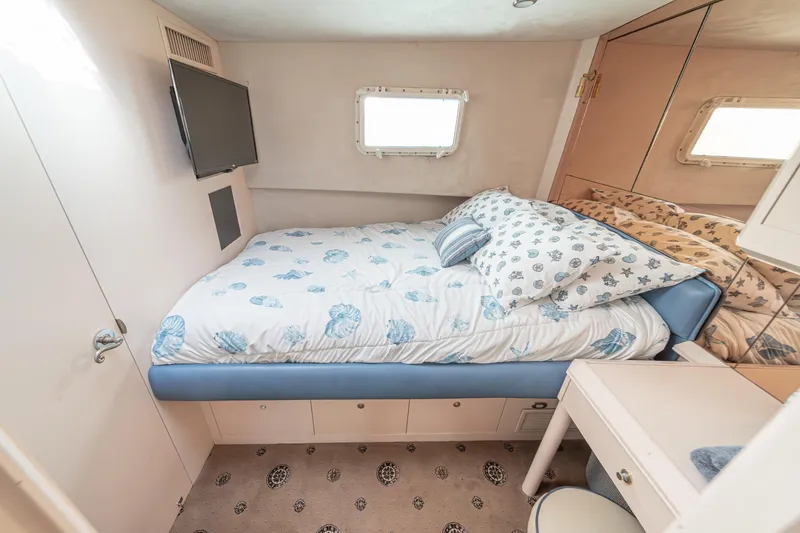 Slide: The Image of Cozy bedroom in 1995 Nordlund Cockpit Motor Yacht with nautical-themed bedding and compact design. - 49