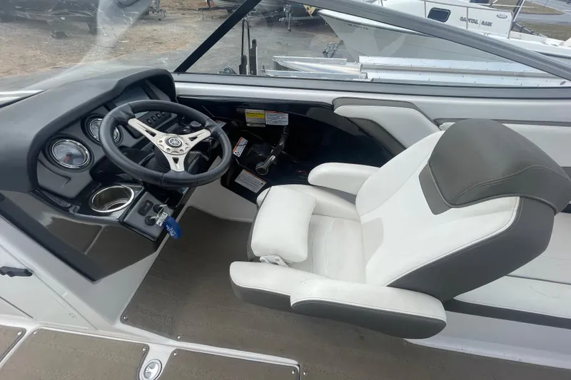 Slide: The Image of 2015 Yamaha Boats 242 Limited S cockpit with steering wheel and captain's chair. - 16