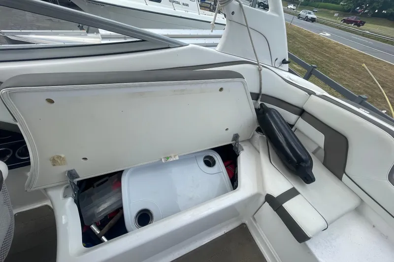Slide: The Image of 2015 Yamaha Boats 242 Limited S interior storage compartment with open lid and visible equipment. - 19