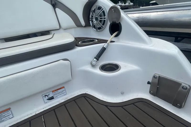 Slide: The Image of 2015 Yamaha Boats 242 Limited S interior with speaker, cup holders, and hose connection. - 24