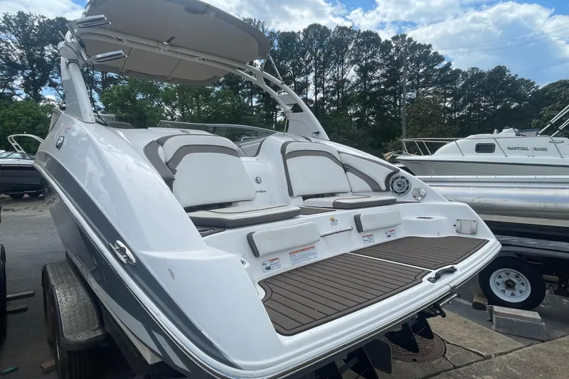 Slide: The Image of 2015 Yamaha Boats 242 Limited S on trailer, featuring sleek design and spacious seating. - 25
