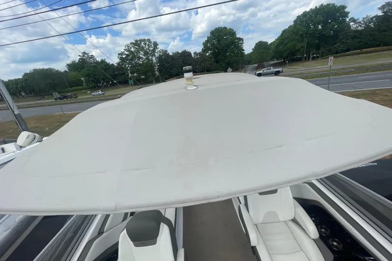 Slide: The Image of 2015 Yamaha Boats 242 Limited S with canopy, parked near a road under a cloudy sky. - 4