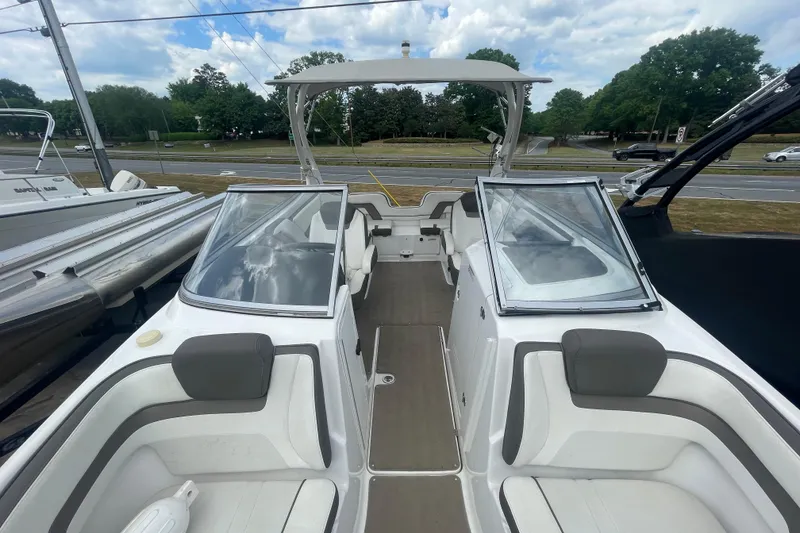 Slide: The Image of 2015 Yamaha Boats 242 Limited S interior with seating and open windshield, docked outdoors. - 5