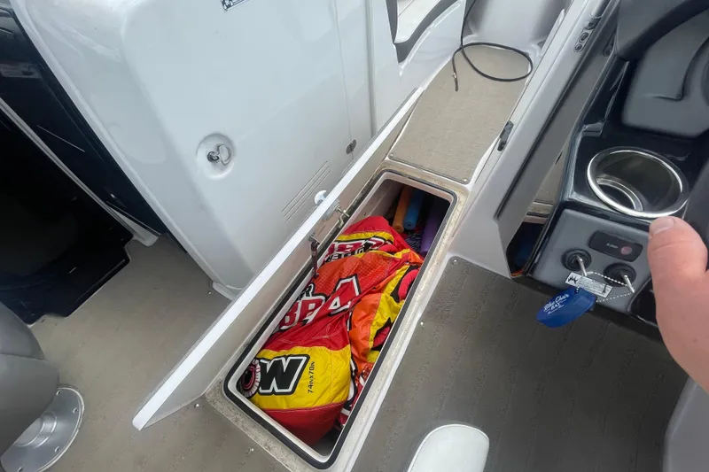 Slide: The Image of Storage compartment on 2015 Yamaha Boats 242 Limited S, containing colorful gear. - 9