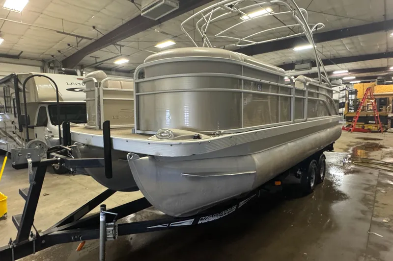 The Image of 2014 Bennington 22 SSX pontoon boat on trailer in indoor storage facility. - 1