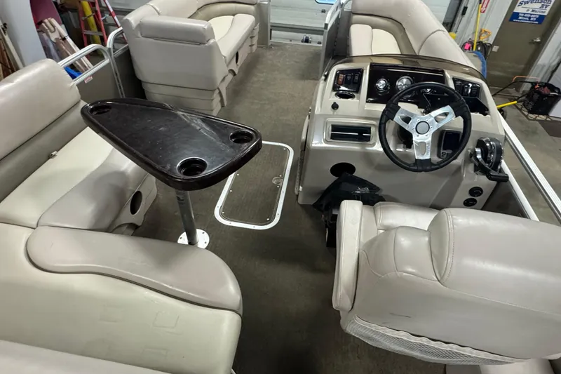 Slide: The Image of Interior of a 2014 Bennington 22 SSX pontoon boat with beige seating and steering console. - 16
