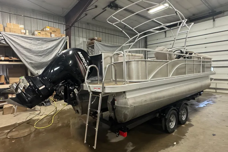 Slide: The Image of 2014 Bennington 22 SSX pontoon boat with Mercury outboard motor in a storage facility. - 3