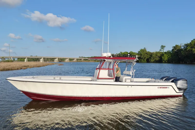 The Image of 2006 Contender 33 Tournament boat on a calm river with a bridge in the background. - 0