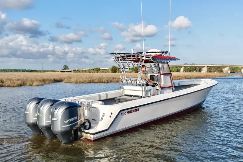 Slide: The Image of 2006 Contender 33 Tournament boat with triple Yamaha engines on a calm waterway. - 10