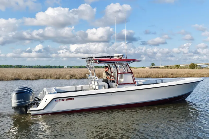 Slide: The Image of 2006 Contender 33 Tournament boat on water with Yamaha engines, under a cloudy sky. - 11