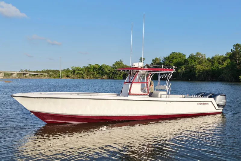 Slide: The Image of 2006 Contender 33 Tournament boat on calm water, featuring a sleek design and dual engines. - 12